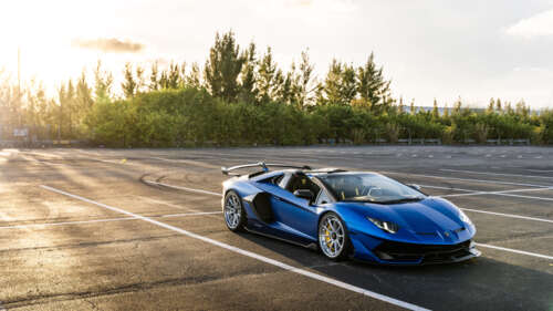 A close-up shot of a luxury Lamborghini sports car showcasing its aerodynamic silhouette. 8K hd background