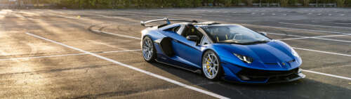 A close-up shot of a luxury Lamborghini sports car showcasing its aerodynamic silhouette. Dual UHD