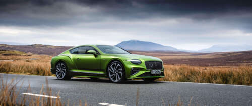 A luxurious green Bentley Continental GT Speed parked in a professional setting,... UWUHD free background