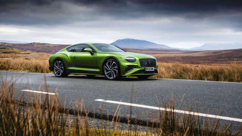 A luxurious green Bentley Continental GT Speed parked in a professional setting,... 4K (Ultra HD) free background