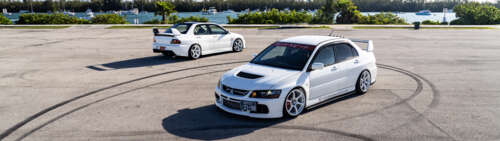 A detailed view of a Mitsubishi Lancer Evolution IX sports sedan showcasing its aerodynamic... Dual UHD pictures for wallpaper