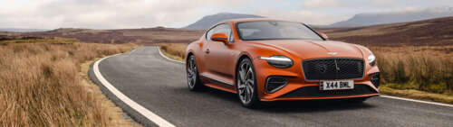 A vibrant orange Bentley Continental GT Speed showcasing its luxurious design and... Dual UHD