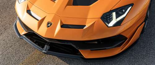 A sleek and powerful Lamborghini Aventador SVJ supercar featuring aggressive aerodynamic... UWUHD free background