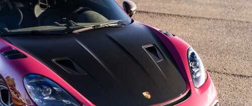 A high-detail shot of a sleek Porsche sports car reflecting light. UWUHD pictures for wallpaper