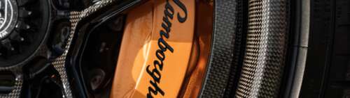 A high-detail shot of a Lamborghini Aventador SVJ supercar featuring its iconic aerodynamic... Dual UHD desktop wallpaper