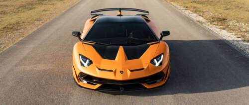 A close-up view of a Lamborghini Aventador SVJ, featuring its sleek aerodynamic bodywork... UWUHD
