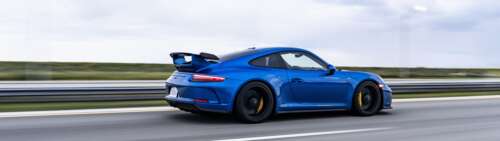 A high-performance Porsche GT3 RS sports car featuring aerodynamic racing elements. Dual UHD wallpaper for laptop download
