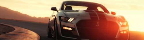 A sleek silver Ford Mustang Shelby GT500 muscle car parked. Dual UHD wallpaper images
