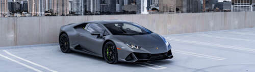 A close-up shot of a modern Lamborghini Huracán supercar in a dramatic setting. Dual UHD