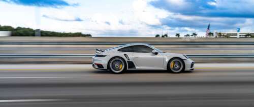 A close-up view of a luxury Porsche sports car featuring a sleek design and metallic... UWUHD