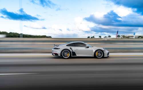 A close-up view of a luxury Porsche sports car featuring a sleek design and metallic... 7680x4800 hd background