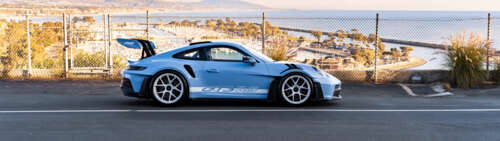 A sleek and polished Porsche sports car featuring modern aerodynamic design. Dual UHD desktop wallpaper