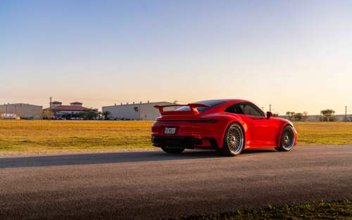 A high-resolution, close-up shot of a sleek Porsche 992 GTS sports car featuring... 7680x4800 high definition wallpaper