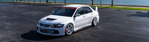 High-performance Mitsubishi Lancer Evolution IX sports sedan in a striking pose Dual UHD free wallpaper for computer