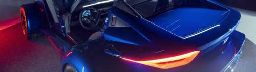 A sleek, metallic silver sports car reflecting soft studio lights against a dark... Dual UHD