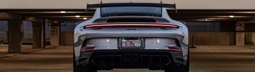 A detailed close-up of a high-performance Porsche 911 GT3 RS sports car. Dual UHD wallpaper for pc download