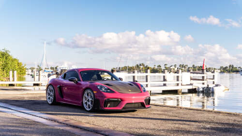 A luxury Porsche sports car parked on a modern urban street during twilight. 4K (Ultra HD)