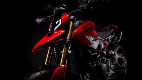 A highly detailed 2026 Ducati Hypermotard V2 motorcycle featured against a dark,... free wallpaper