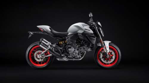 A 2026 Ducati Monster V2 sports motorcycle captured in a dark, high-contrast setting. high definition wallpaper