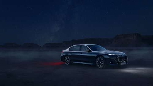 A luxurious 2025 BMW 760i xDrive sedan illuminated under night lights, showcasing... wallpaper images
