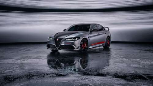 A sleek Alfa Romeo Giulia Quadrifoglio sports sedan positioned against a dark, moody... wallpaper download