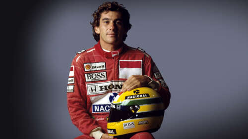 A Formula 1 driver wearing a racing suit with the colors of the Brazilian flag, looking... free wallpaper