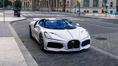 A white Bugatti W16 Mistral hypercar driving on a city road in Toronto. wallpaper download