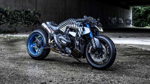 A custom BMW R 1300 R Titan motorcycle parked against a colorful graffiti wall in... wallpaper