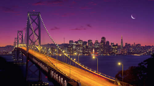A long exposure photograph of the San Francisco-Oakland Bay Bridge under a purple... hd background