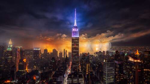 The Empire State Building at night with colorful fireworks exploding over the New... free background images