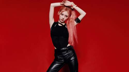Gaeul from the K-pop group IVE wearing a chic black dress against a vibrant red background. free wallpaper