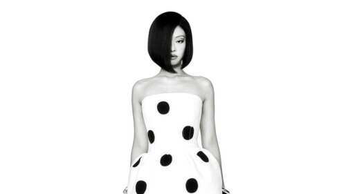 A high-contrast, monochrome close-up portrait of Jennie Kim against a clean white...