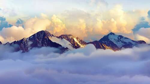 A panoramic view of snow-covered mountain ranges in the Alps, shrouded in thick white... wallpaper