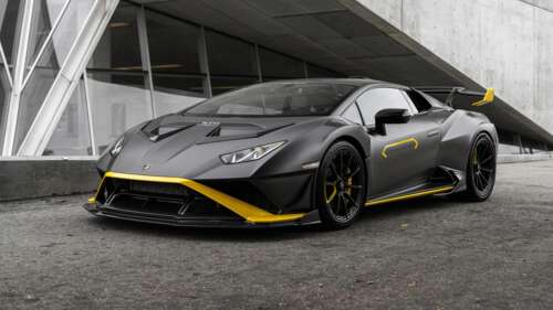 A high-resolution close-up of a matte black Lamborghini Huracán STO supercar featuring... wallpaper