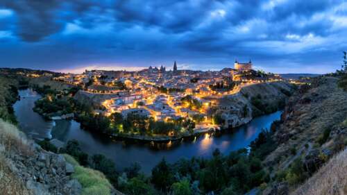 A wide panoramic view of a Spanish city at night featuring brilliant urban lights... wallpaper download