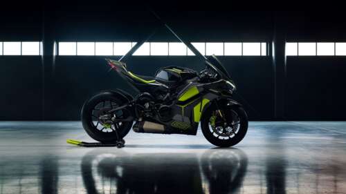 A Ducati Panigale V4 motorcycle and a Lamborghini supercar parked in a garage with... high definition wallpaper