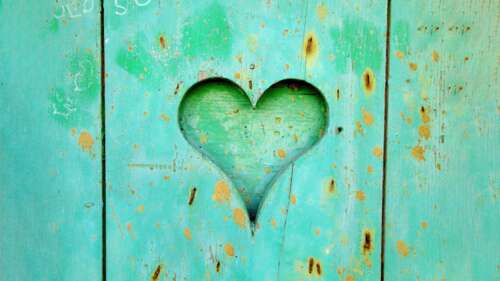 A pastel cyan heart resting on a rustic wooden background. desktop wallpaper