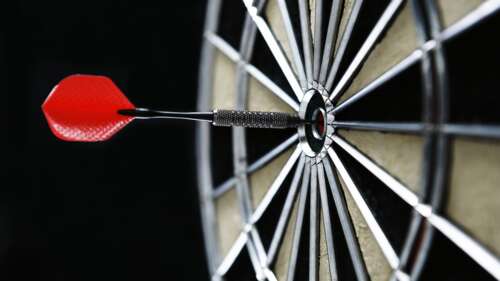 A vivid red and white bullseye target centered on a stark, pitch-black background. free wallpaper