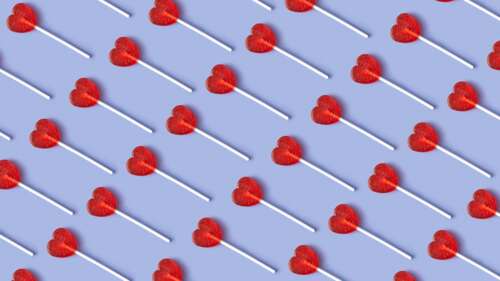 A detailed pattern of red heart-shaped lollipops and various sweet candies. wallpaper