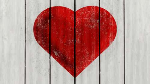 A bright red heart centered on a background of dark, rustic wooden planks. free background