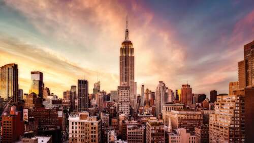 The Empire State Building in New York City during a beautiful sunset with warm orange... wallpaper images