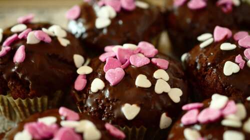 A close-up arrangement of chocolate muffins, a chocolate cupcake, and various heart-shaped... wallpaper