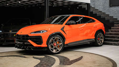 A vibrant orange Lamborghini Urus SE featuring a custom TopCar Design widebody kit. free wallpaper