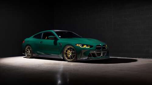 A high-resolution shot of a BMW M4 Coupe against a dark, minimalist background.