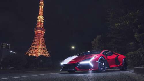 A sleek Lamborghini Revuelto parked at night in front of the illuminated Tokyo Tower,... wallpaper