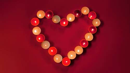 A deep red heart shape centered on a dark crimson aesthetic background. wallpaper