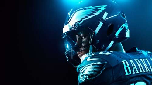A dramatic cinematic shot of American football player Saquon Barkley illuminated... free background