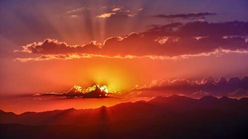 A scenic view of a breathtaking sunset with sun rays illuminating the evening sky... free wallpaper