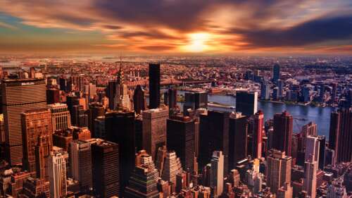 A dramatic New York City skyline at sunset with a cloudy, colorful sky. pictures for wallpaper