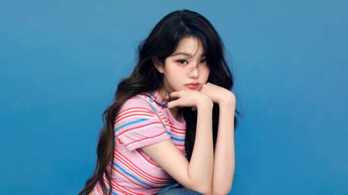 A high-resolution close-up of K-pop star Jang Wonyoung with a vivid blue background background images hd